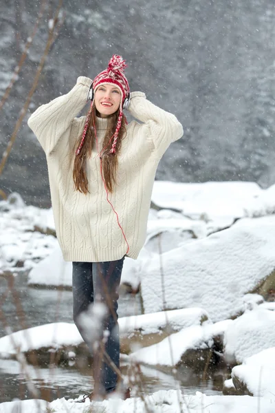 Flicka lyssna på musik i vinterlandskap — Stockfoto