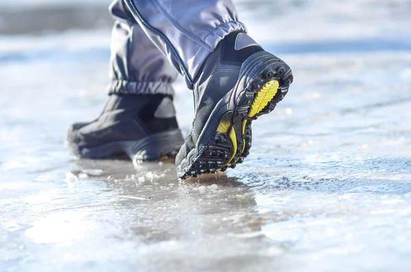 Winter boots walking on snowy sleet road — Stock Photo, Image