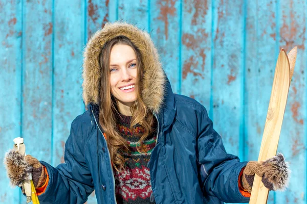 Beautiful woman with retro ski over vintage wooden wall — Stock Photo, Image