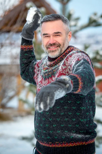 冬の楽しい男幸せ笑顔で雪玉を投げる — ストック写真