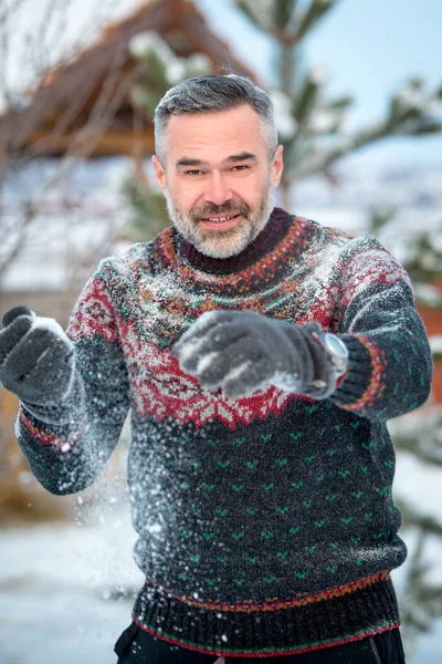 Winterpret man gelukkig lachend en sneeuwballen gooien — Stockfoto