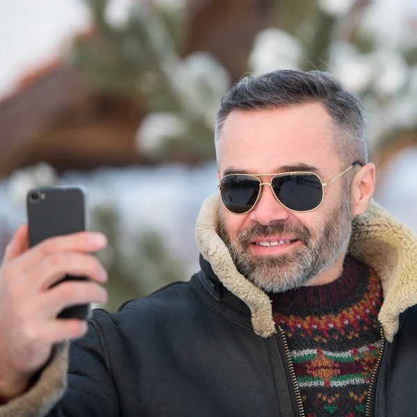 Schöner Mann macht ein Foto von sich mit dem Smartphone — Stockfoto