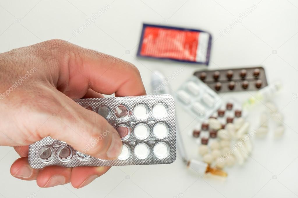 man taking pill out from blister pack at home