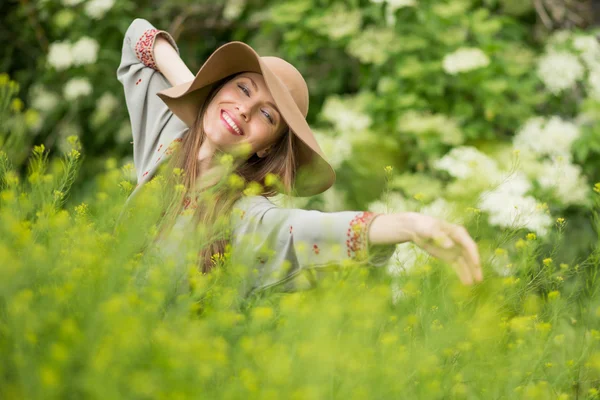Lente vrouw in groene tuin genieten van de zonnige dag — Stockfoto