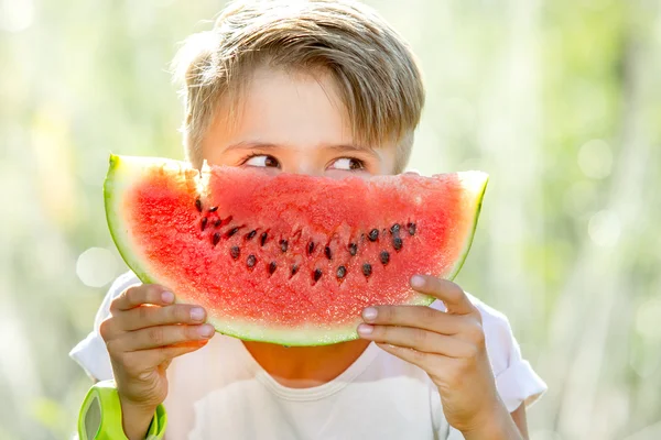 Lustiger verspielter Junge isst Wassermelone — Stockfoto