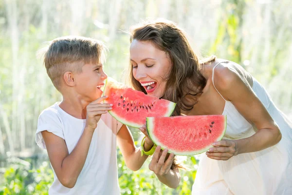 Bir güneşli yaz gününde karpuz yeme mutlu gülümseyen aile