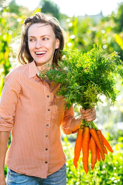 Gardening - Beautiful gardener with carrots — Stock Photo, Image