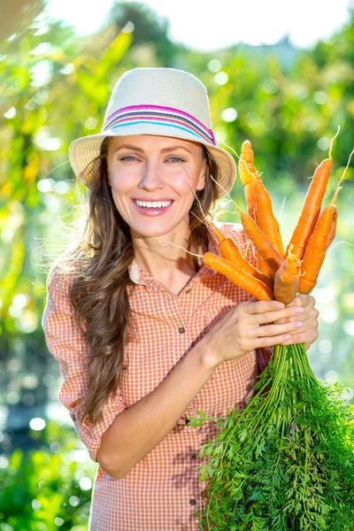 Beautiful gardener with oragenic carrot — Stock Photo, Image