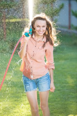 Bir Bahçe Sulama yaparken eğlenmek genç seksi kadın