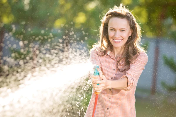 Young sexy woman  having fun while watering a garden — Stock Photo, Image