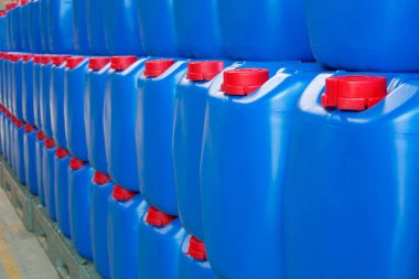 Kimyasalları paketlemek için kırmızı başlıklı mavi ambalajlar depolanmış ve organize edilmiştir. Kimyasalların kalitesini korumak için plastik kovalar