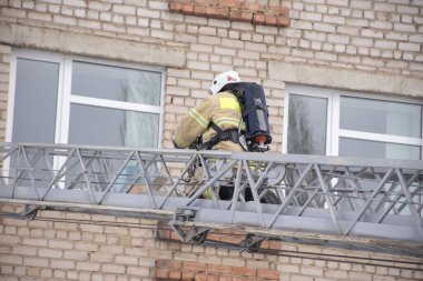 İtfaiyeci evin penceresine çıkan merdivenleri tırmanır..
