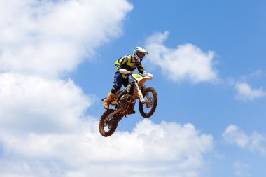 Wingate, Israel - July 23, 2016: Motocross riders and bikes clearing a tabletop jump during the final heat of the race