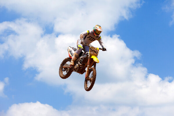 Wingate, Israel - July 23, 2016: Motocross riders and bikes clearing a tabletop jump during the final heat of the race