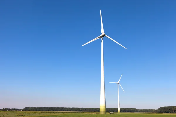 Wind turbine spinning with in a green countryside environment Royalty Free Stock Images