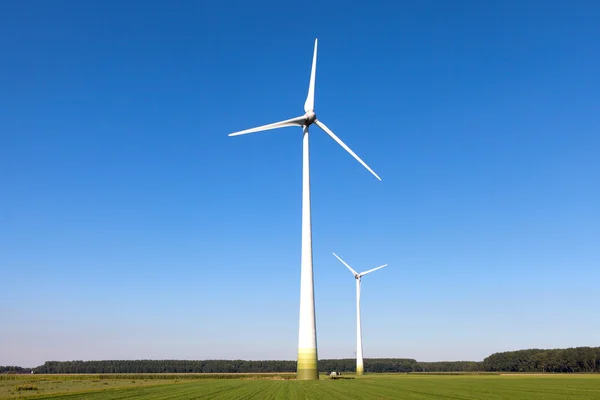 Wind turbine spinning with in a green countryside environment Stock Picture