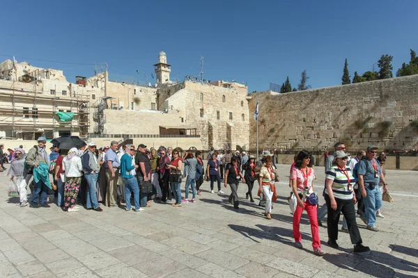 Turistas en Jerusalén llorando complejo mural con el cielo azul, la bandera israelí y el muro de lamentación en el fondo — Foto de Stock