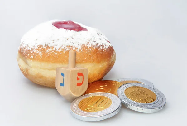 Hanukkah doughnut and spinning top - Traditional jewish holiday food and toy. — Stock Photo, Image