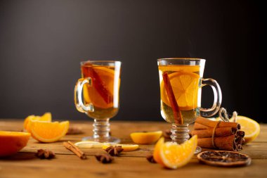 Tarçınlı çay, limon ve diğer baharatlar masada duruyor.