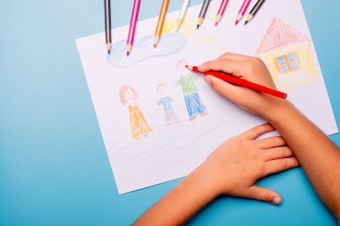 Küçük çocuk masaya tebrik kartı çiziyor. Aile Günü konsepti