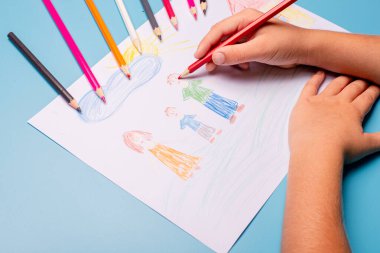 Küçük çocuk masaya tebrik kartı çiziyor. Aile Günü konsepti