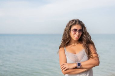 Güzel genç bir kadın sahilde dinleniyor.