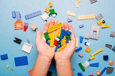 Bir sürü renkli plastik blokla oynayan bir çocuğun elleri yakın plan. Çocuk eğleniyor. Yaratıcı eğlence modern teknik ve robotik.