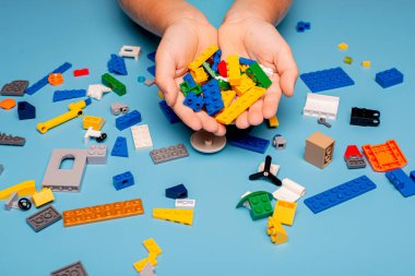 Bir sürü renkli plastik blokla oynayan bir çocuğun elleri yakın plan. Çocuk eğleniyor. Yaratıcı eğlence modern teknik ve robotik.