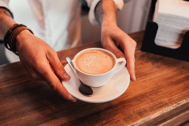 Kahveci elinde bir fincan lezzetli kahve tutuyor..