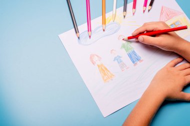 Küçük çocuk masaya tebrik kartı çiziyor. Aile Günü konsepti