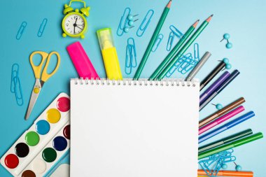 Mavi panoda kopya alanı olan çeşitli okul aksesuarları. Okula dönüş kavramı.