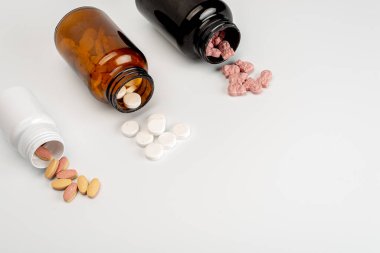 Arka planda vitamin hapları ve şişeler