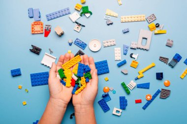 Bir sürü renkli plastik blokla oynayan bir çocuğun elleri yakın plan. Çocuk eğleniyor. Yaratıcı eğlence modern teknik ve robotik.