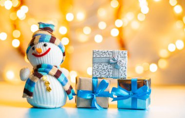 Kardan adam ve hediyeler Bokeh arka planındaki ahşap masada