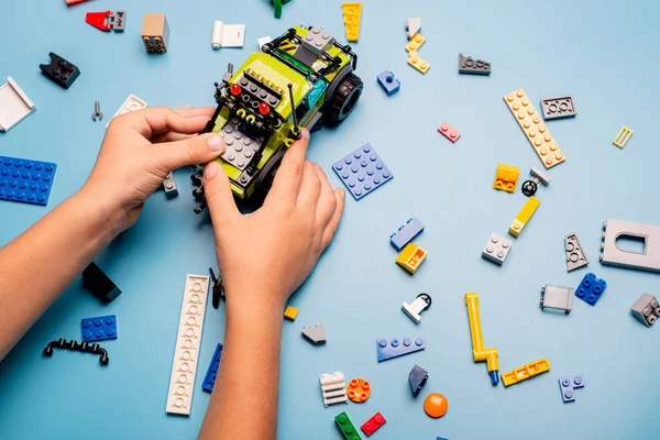 カラフルなプラスチックブロックの多くで遊んで子供の手の閉鎖 子供は楽しんでる 創造的なレジャー近代的な技術とロボット — ストック写真
