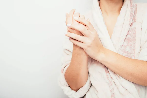 The girl smears her hands with cream. home use of hand cream