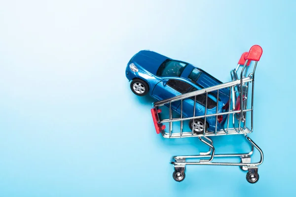 auto dealership and rental car concept. blue car shopping cart blue background