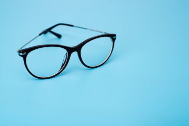 Üst manzara mavi pastel arka planda siyah göz gözlükleri