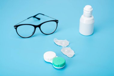 Masanın üzerinde mercek ve çanta olan şişe.