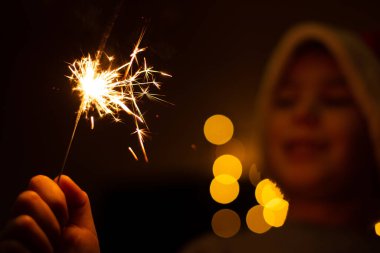 Ellerinde maytap tutan genç bir çocuk