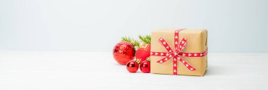 Beyaz tahta arka planda topları olan noel hediyesi kutusu.