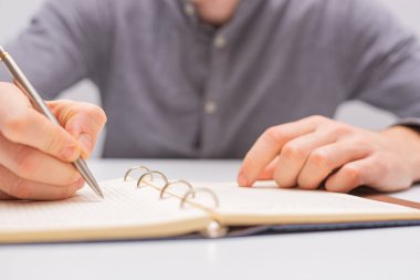  guy makes notes with a pen in a notebook. clipart