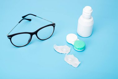 Masanın üzerinde mercek ve çanta olan şişe.