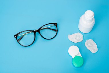 Masanın üzerinde mercek ve çanta olan şişe.