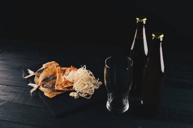 Koyu ahşap masada bira ve kurutulmuş balık. Bira ve bira..