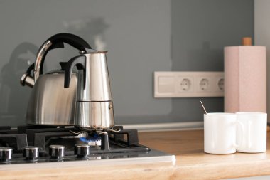 Tahta bir masada bir fincan çay makinası.