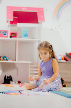 Genç bir kız neşe içinde oyuncaklarla dolu renkli renkli bir oyun odasına daldı.