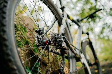 Arka kaset, zincir, raydan çıkarıcı, disk fren pervanesi ve kalibreyi vurgulayan bisiklet sürüş ve fren sisteminin yakın çekim görüntüsü. Mekanik detaylar işlevselliği ve tasarımı gösterir.