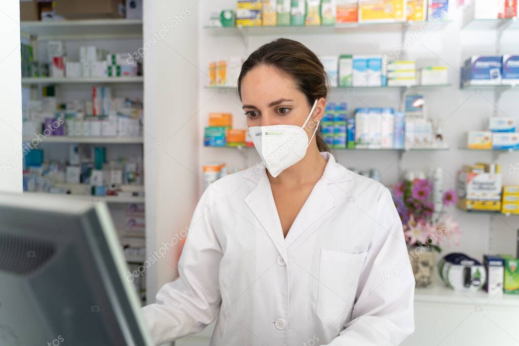 young pretty girl pharmacist consults medicines on her front computer