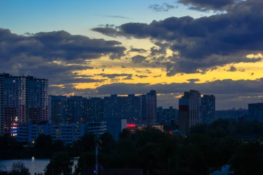 Gün batımında güzel gün batımı ve bulutlar turuncu ve mavi gökyüzü, büyük şehir manzarası
